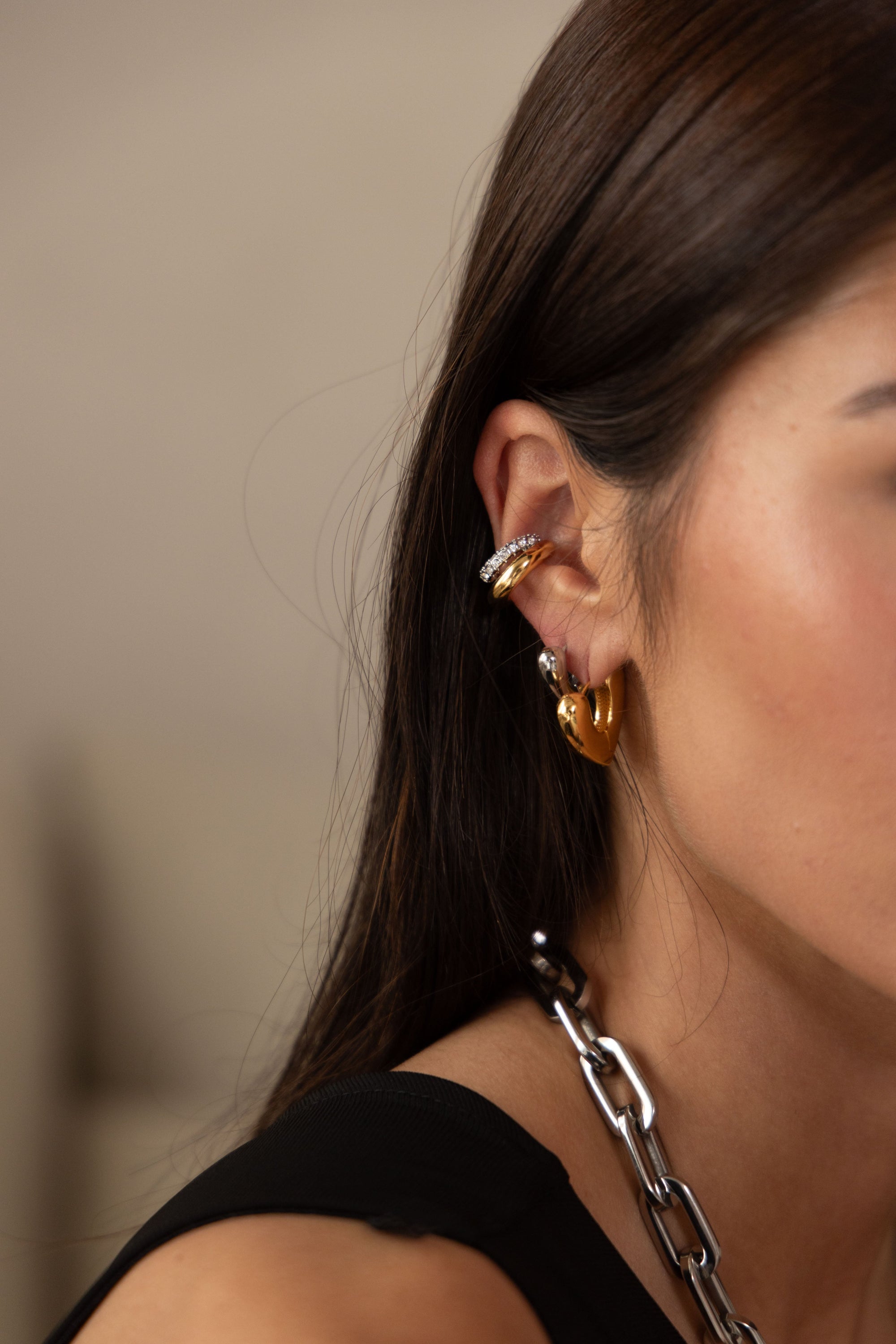 Close-up of Kaia Huggie earrings showing two-tone design