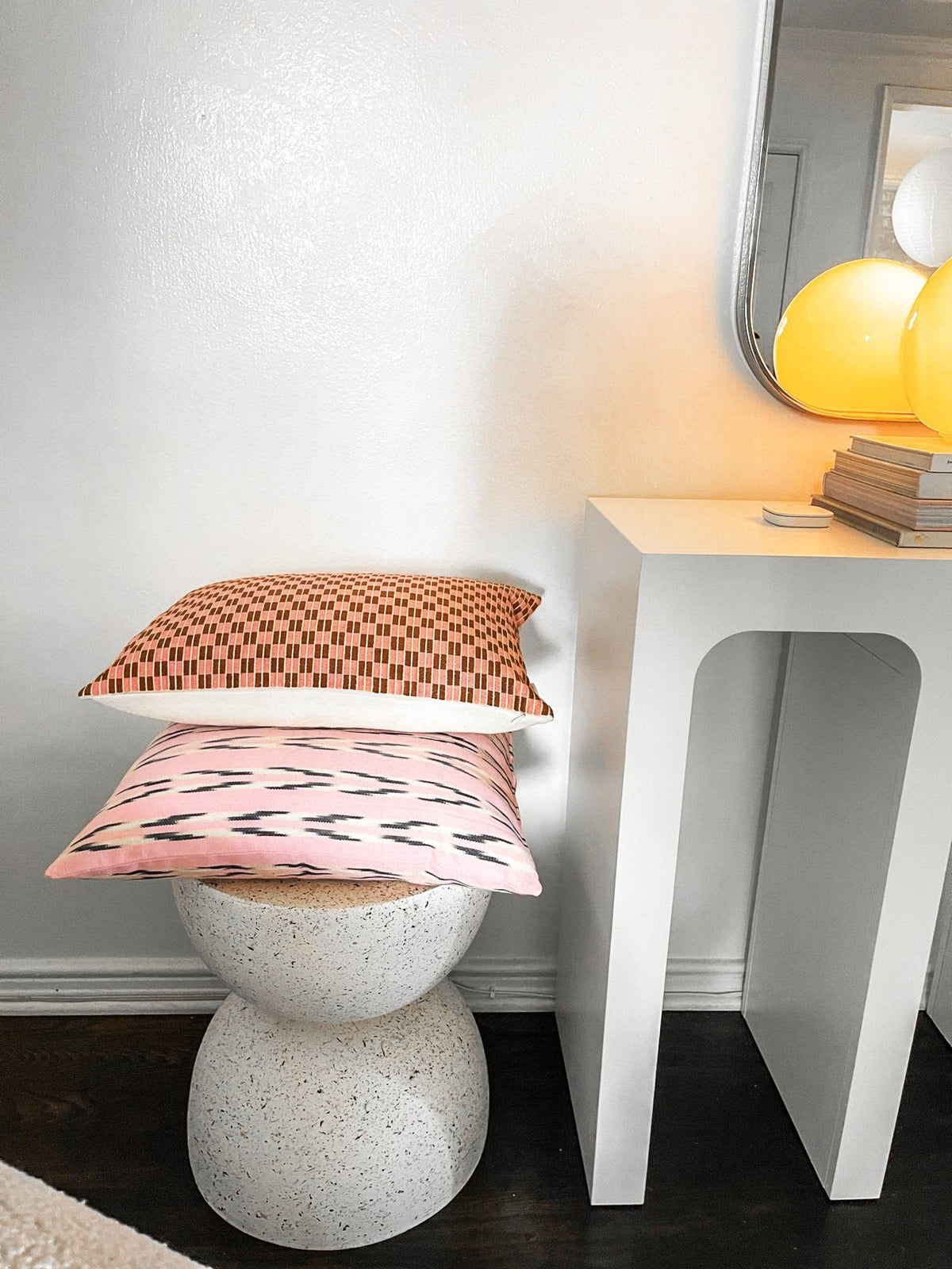 Checkered brocade pillow in pink and umber styled in a living room