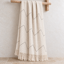 Natural chevron cotton throw with black hand-stitched zigzag pattern