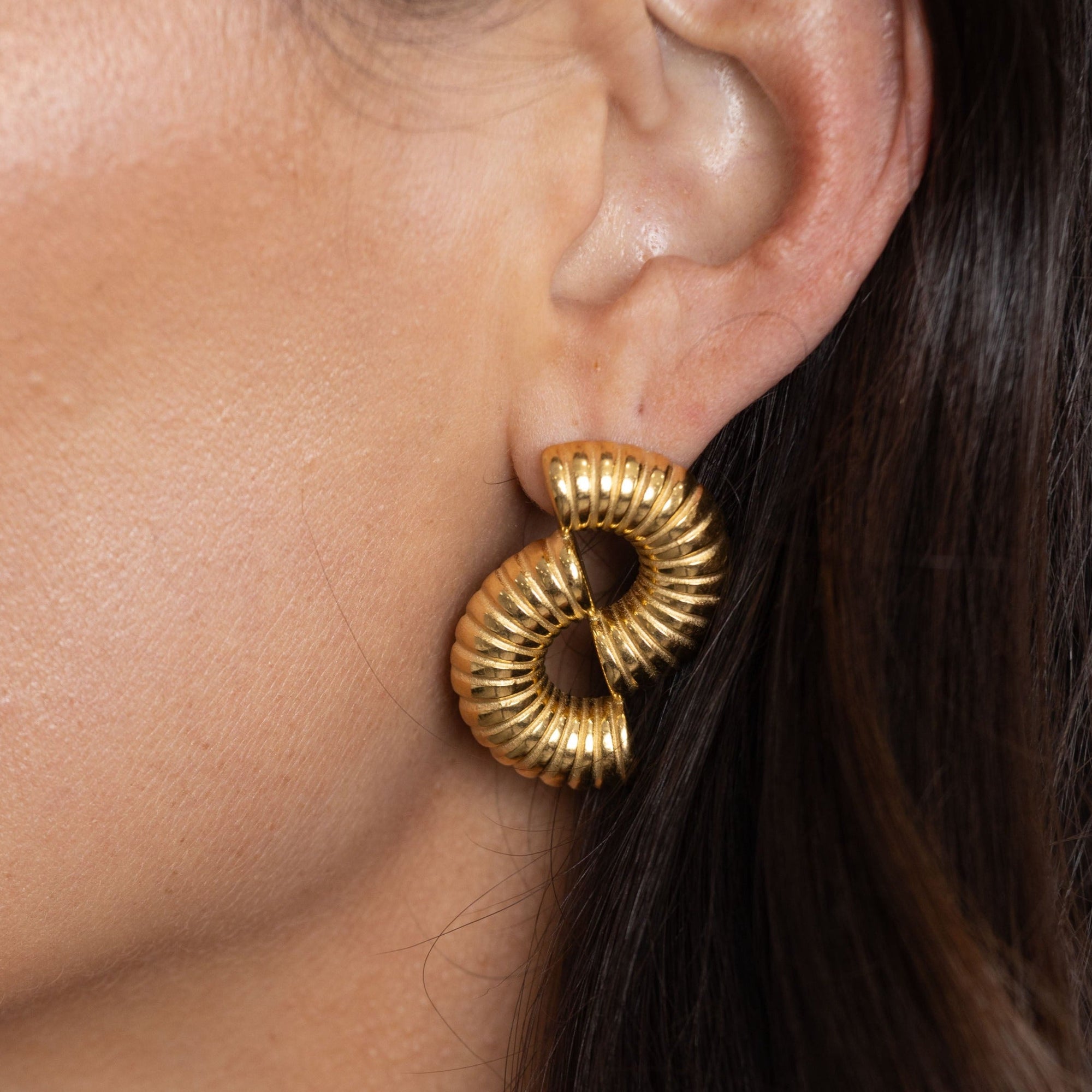 Bold half circle design statement earrings displayed on stand