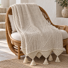 Cream organic cotton throw draped over a rattan chair
