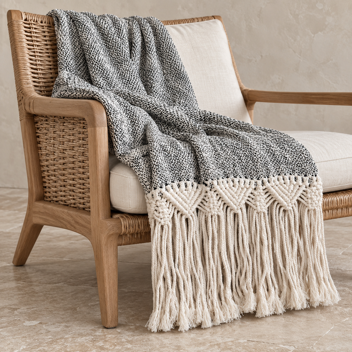 Black Mountain macramé cotton throw on a rattan chair