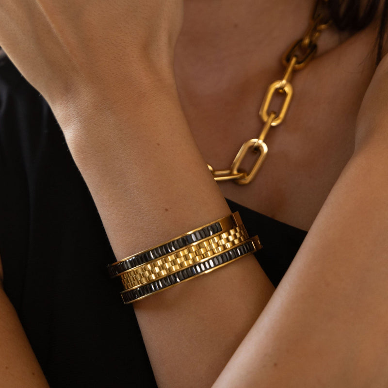 Close-up of watch band style gold bangle on wrist