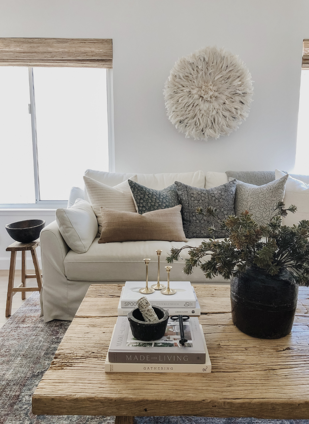 Layered designer decorative pillows styled on a neutral sofa creating a warm modern room look.