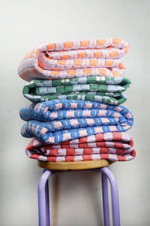 Stack of handwoven quilted Sujani blankets in assorted colors