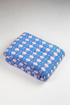 Quilted Sujani throw blanket in soft pink and blue, folded