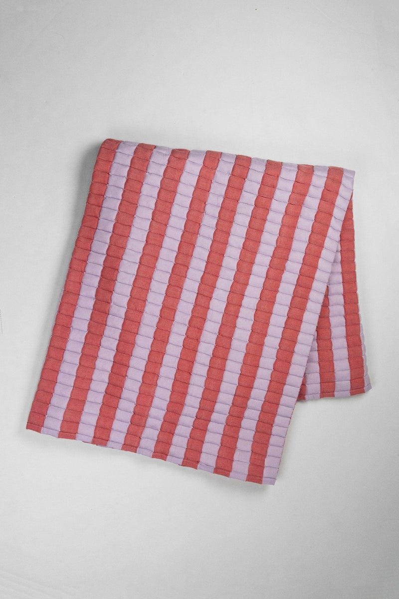 Quilted Sujani throw blanket in soft lilac and red, laid out