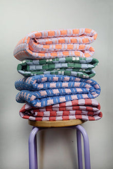 Stack of handwoven quilted Sujani blankets in assorted colors