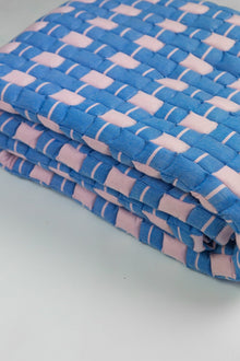 Close-up of the quilted Sujani throw blanket weave in soft pink and blue