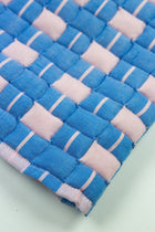 Close-up of the quilted Sujani throw blanket weave in soft pink and blue