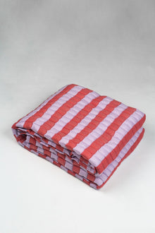 Quilted Sujani throw blanket in soft lilac and red, folded
