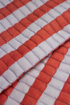 Close-up of the quilted Sujani throw blanket weave in soft lilac and red