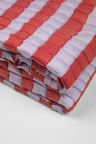 Close-up of the quilted Sujani throw blanket weave in soft lilac and red