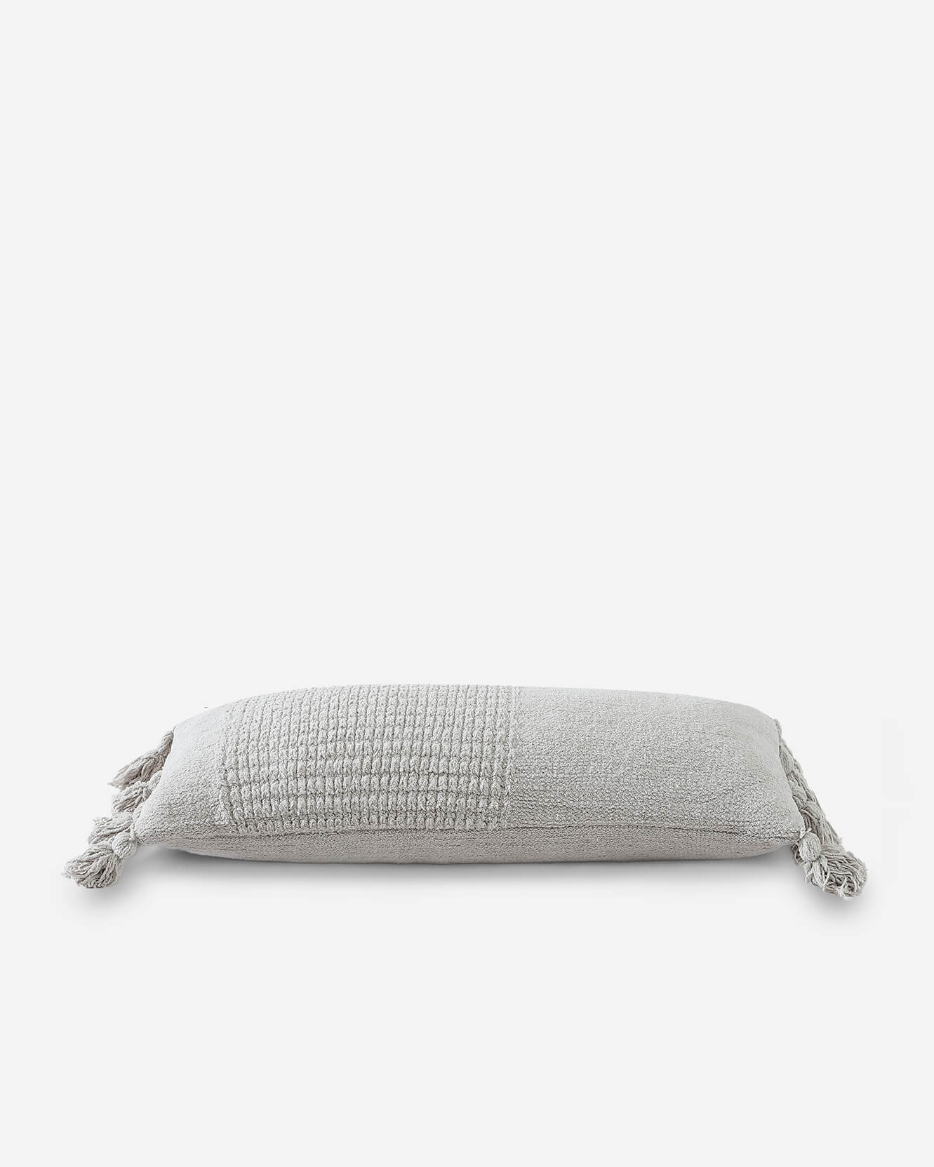 Elongated lumbar pillow in cozy braided design on sofa