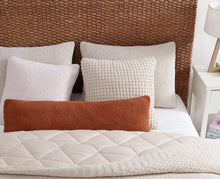 Lumbar and throw pillows in waffle fabric styled on bed