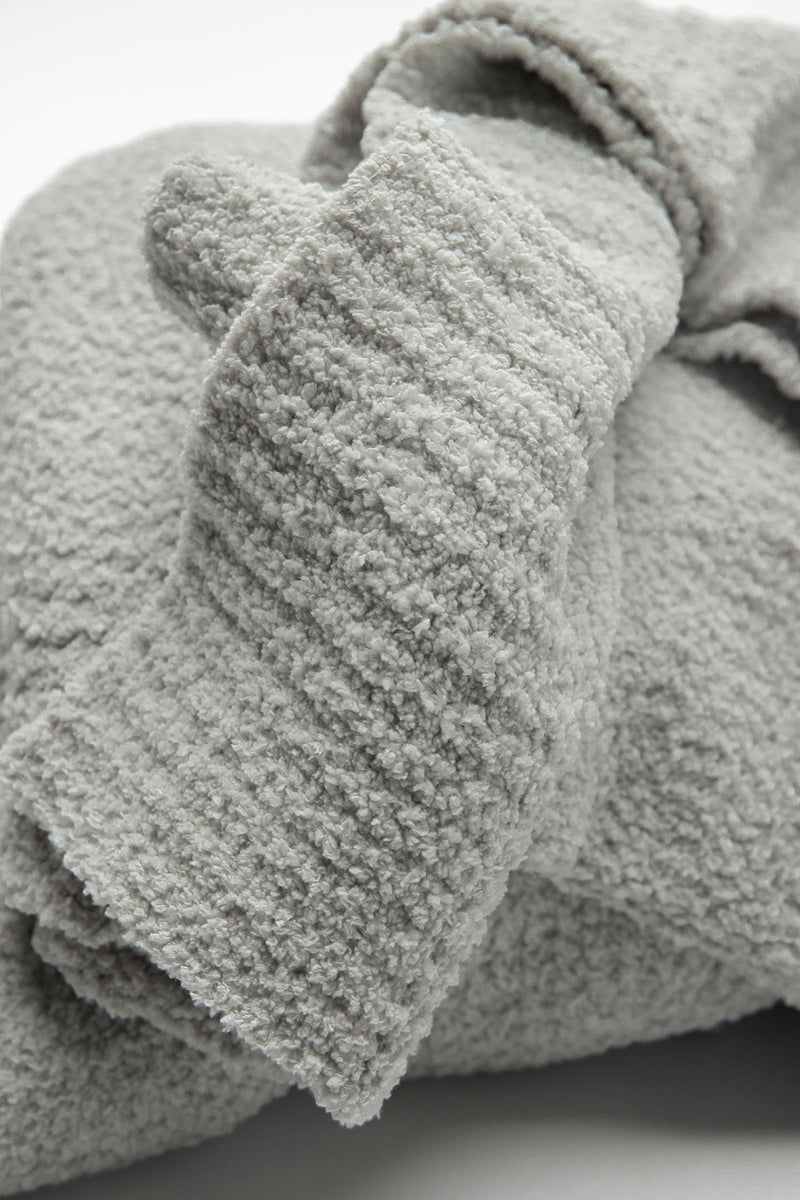 Soft cloudlike snug fabric bed blanket in neutral bedroom