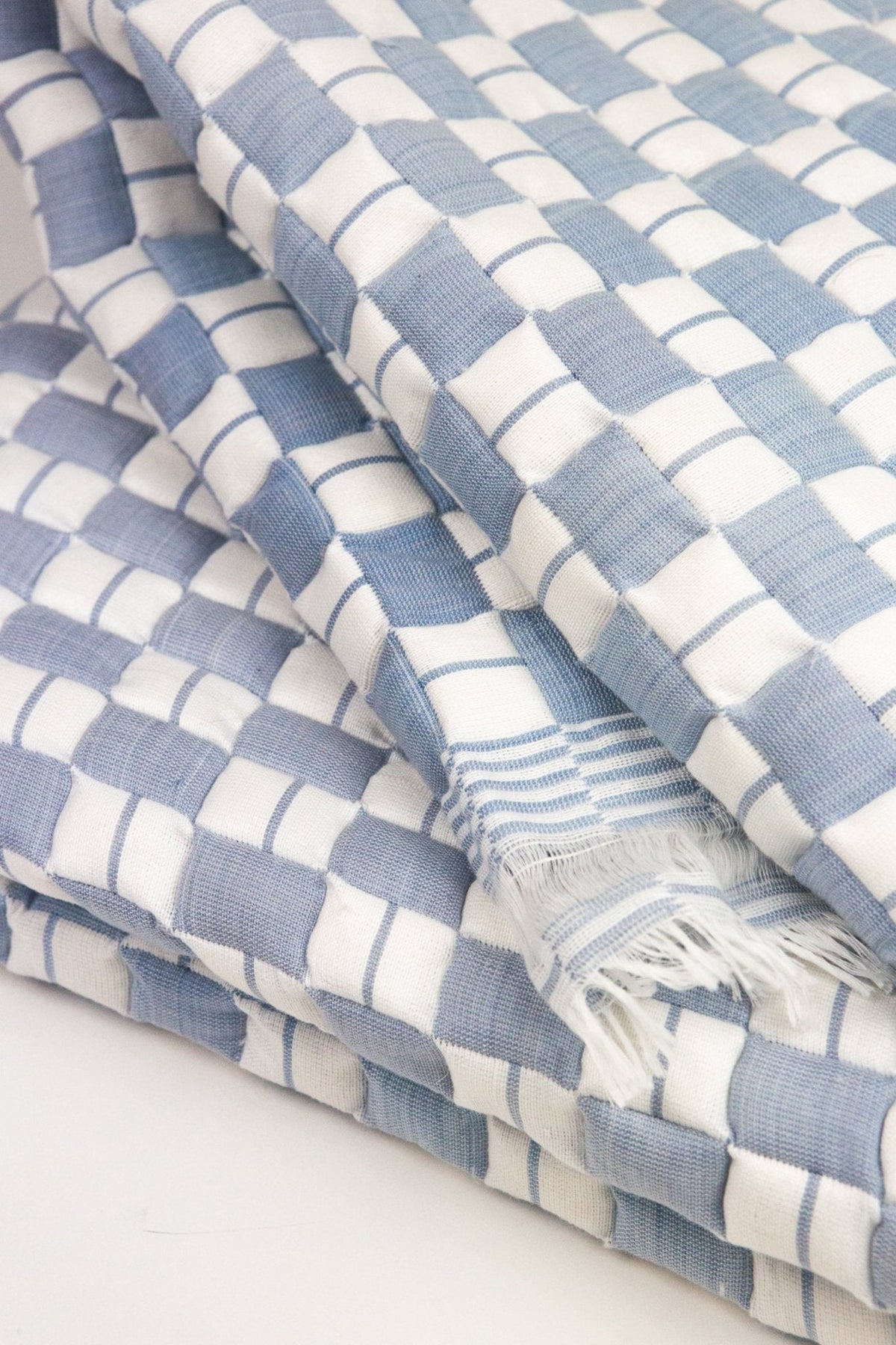 Close-up of the quilted Sujani throw blanket weave in soft blue grey