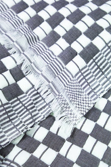 Close-up of the quilted Sujani throw blanket weave in soft black and white