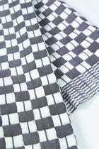 Close-up of the quilted Sujani throw blanket weave in soft black and white