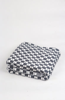 Quilted Sujani throw blanket in soft black and white, styled