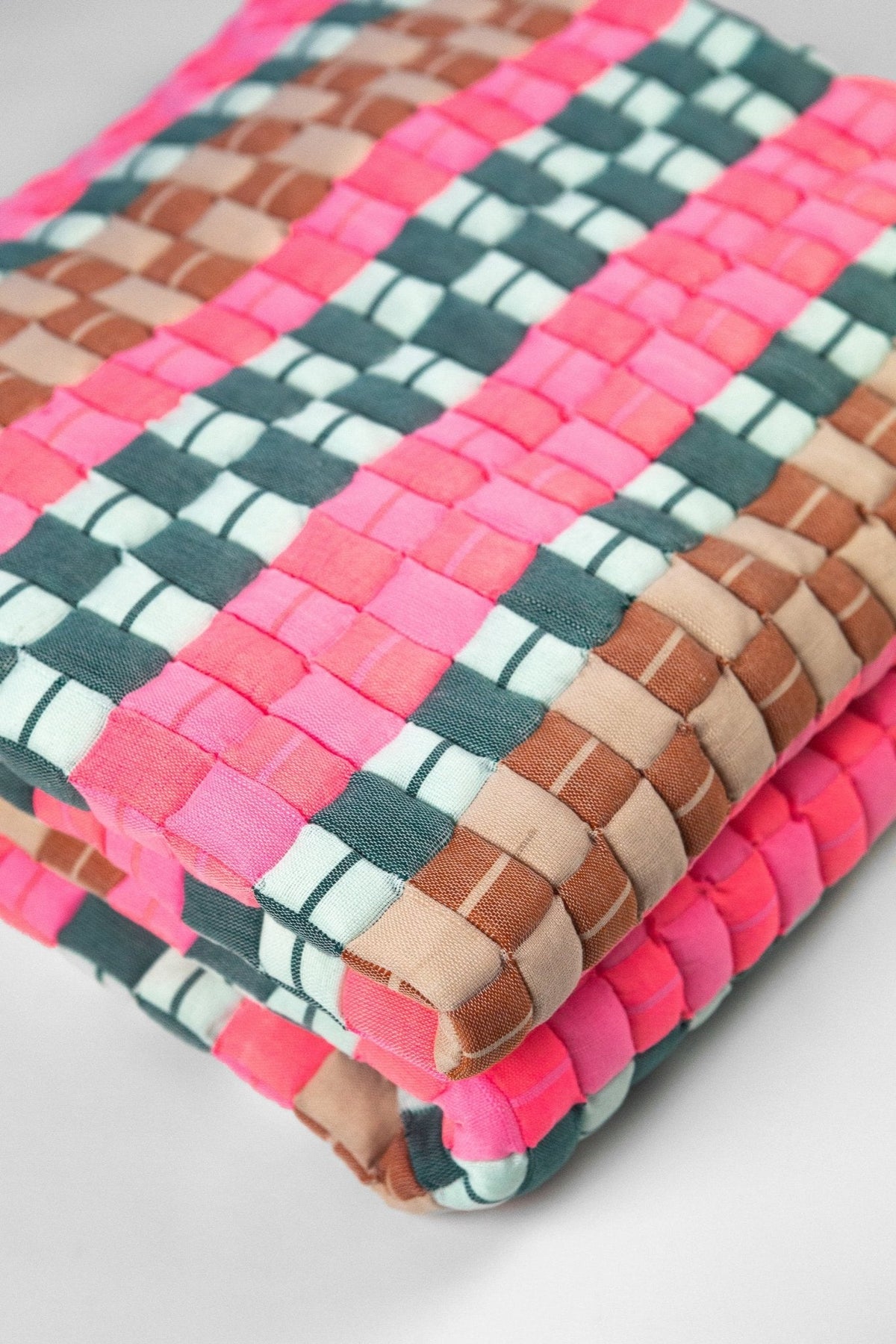 Close-up of the quilted Sujani throw blanket weave in multi green and pink