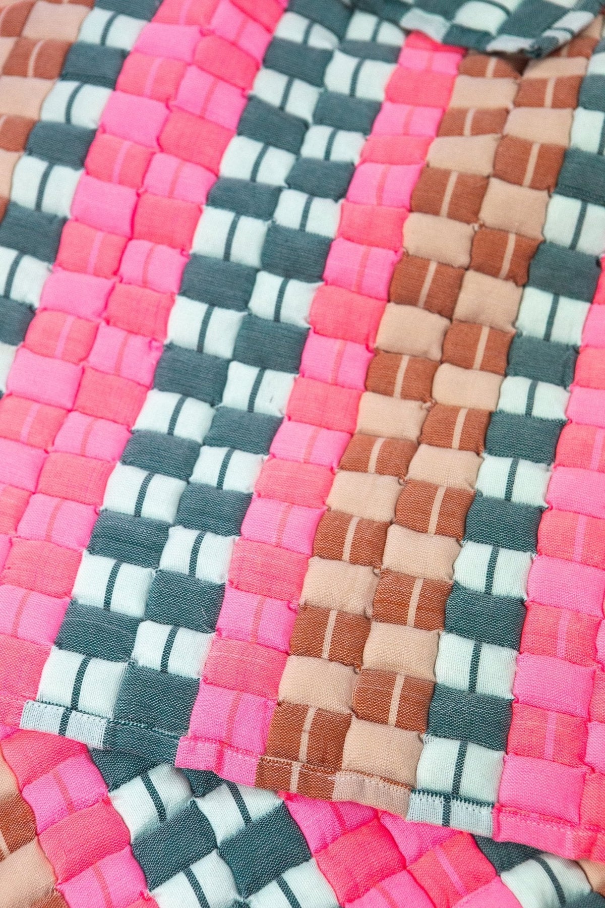 Close-up of the quilted Sujani throw blanket weave in multi green and pink