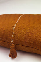 Close-up of the handwoven Antigua pillow in solid umber brown