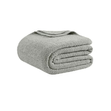 Oversized snug bed blanket draped across modern bed