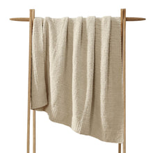 Snug Lap Throw folded on armchair in neutral color