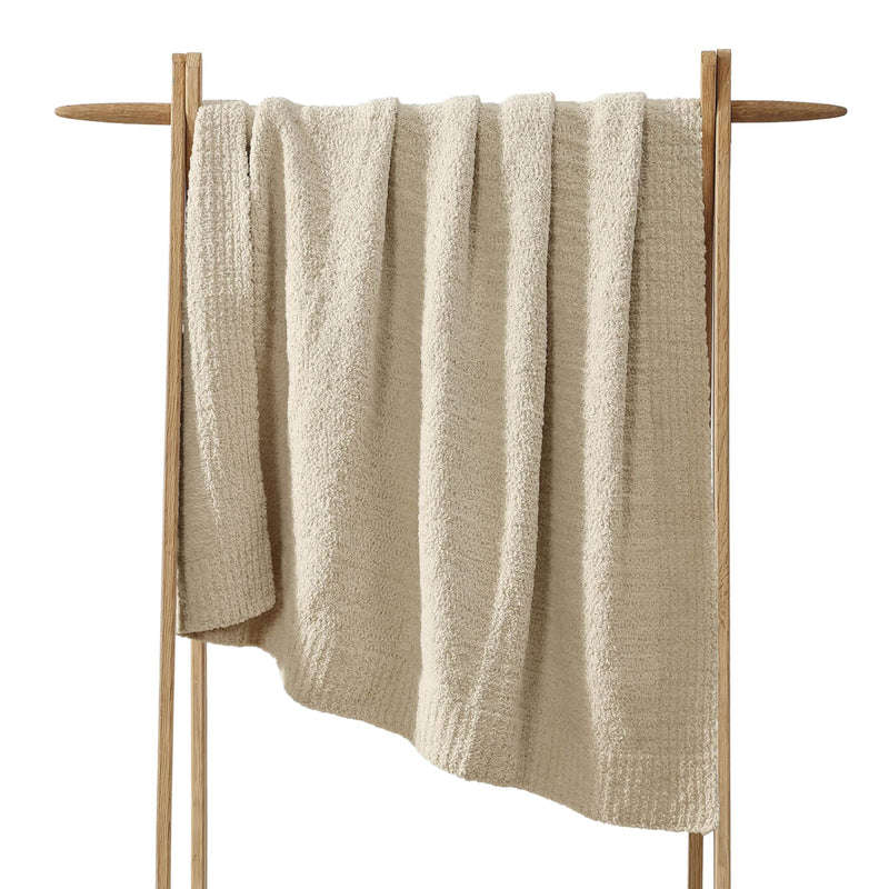 Snug Lap Throw folded on armchair in neutral color