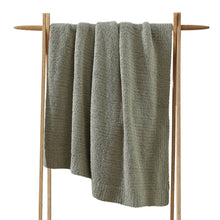 Snug Throw blanket draped over a sofa in neutral tones