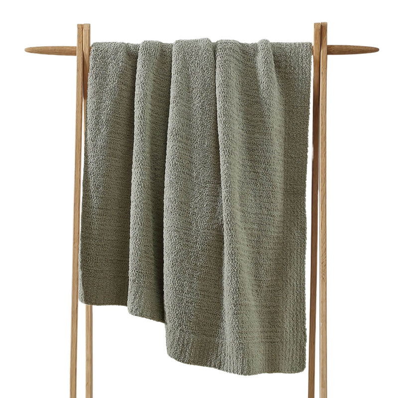 Snug Throw blanket draped over a sofa in neutral tones