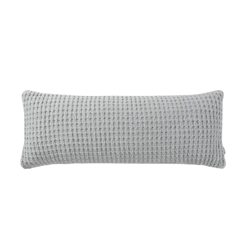 Snug Waffle Lumbar Pillow styled on bed with layered bedding