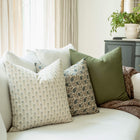 Stella blue floral pillow with navy floral and olive pillows on a sofa