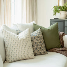 Oxford set with blue block print, navy floral and olive pillows on a sofa