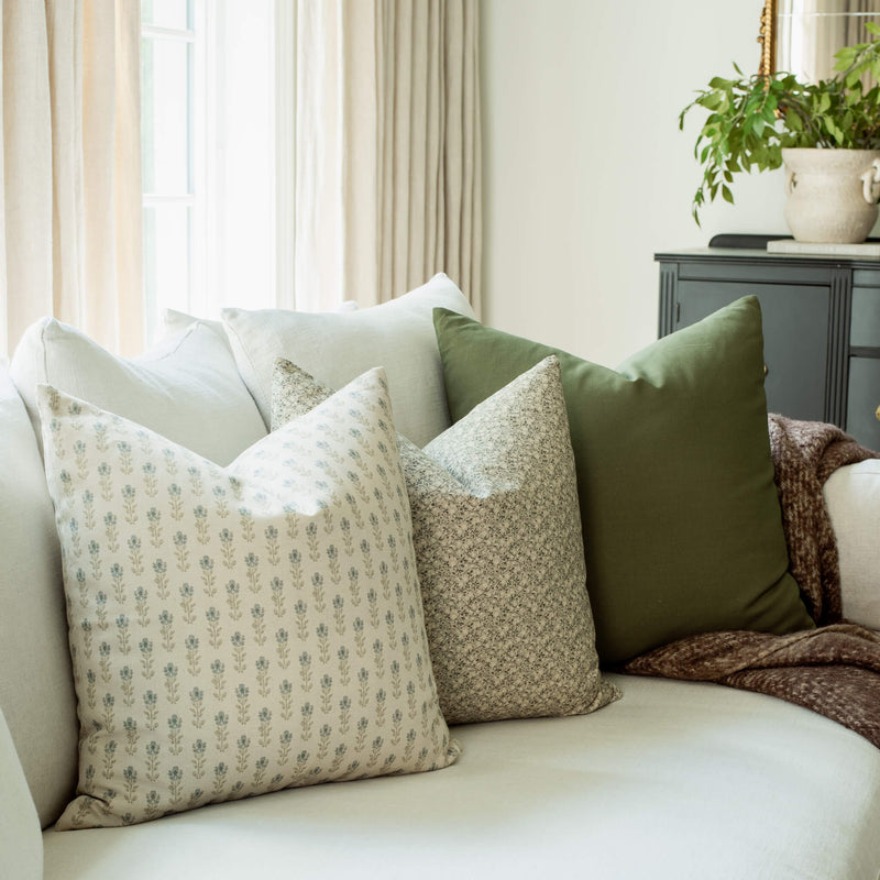 Willow set with blue block print, sage floral and olive pillows on a sofa
