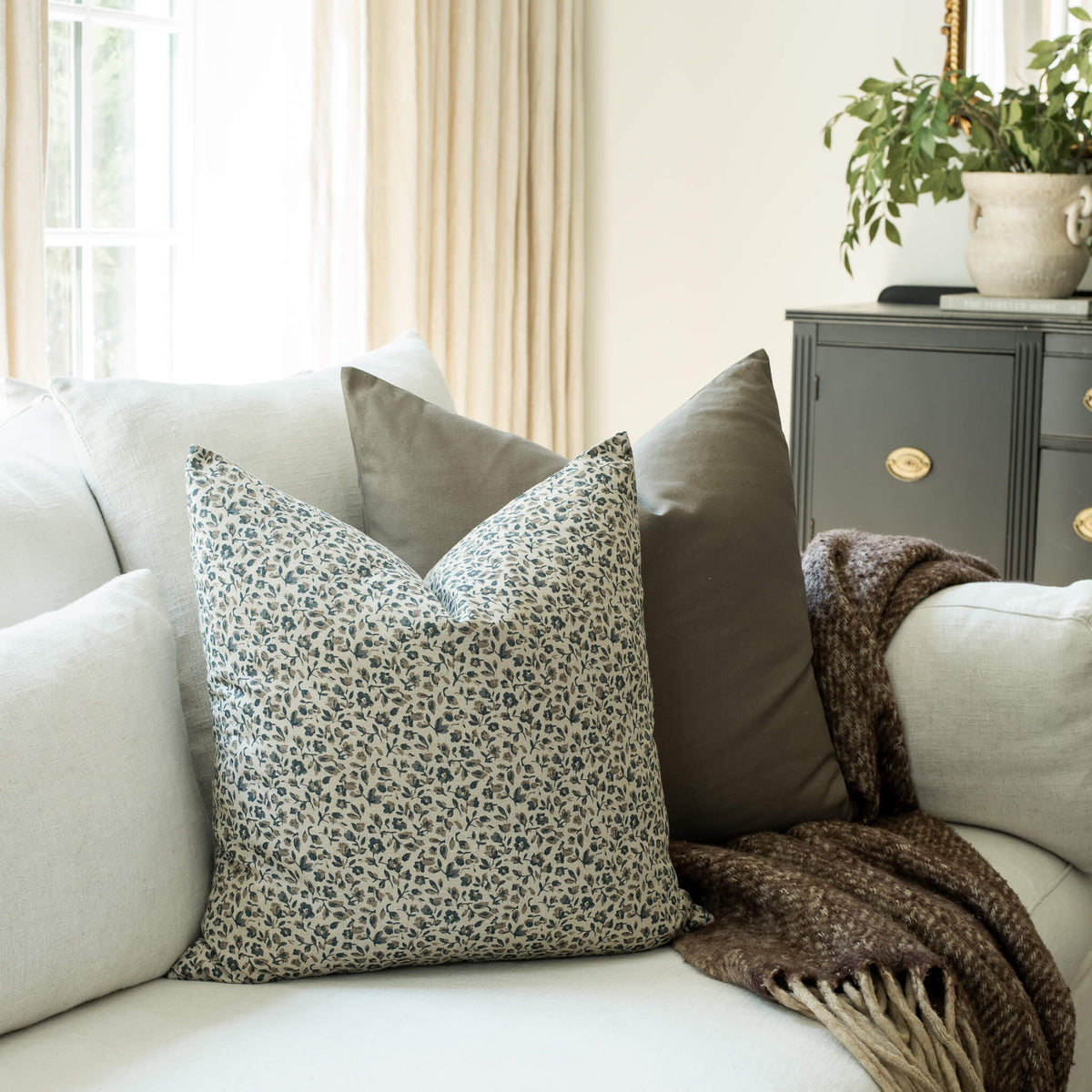 Adeline blue ditsy floral throw pillow cover on a sofa