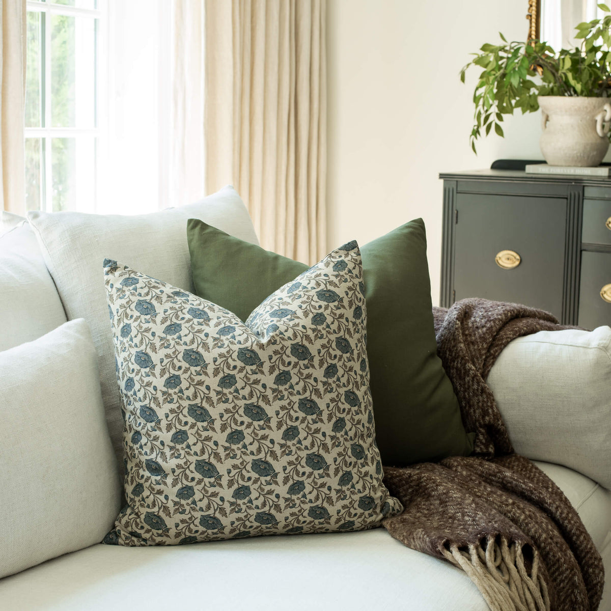 Mabel blue vintage floral throw pillow cover on a sofa