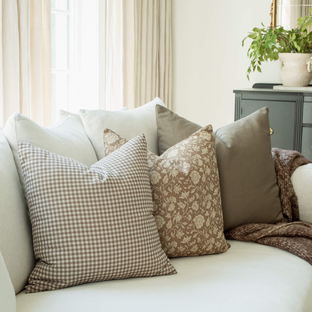 Oakley set with brown gingham and taupe floral pillows on a sofa