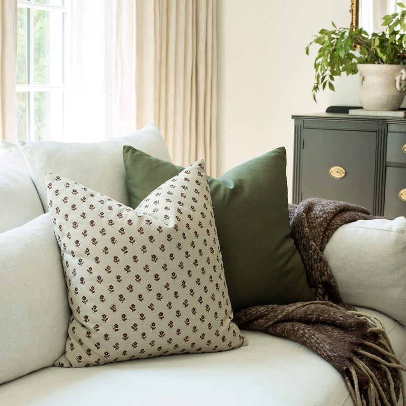 Leme olive green pillow with a burgundy block print pillow on a neutral sofa