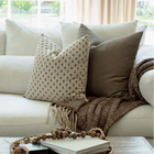 Pippa brown floral pillow styled on a sectional sofa