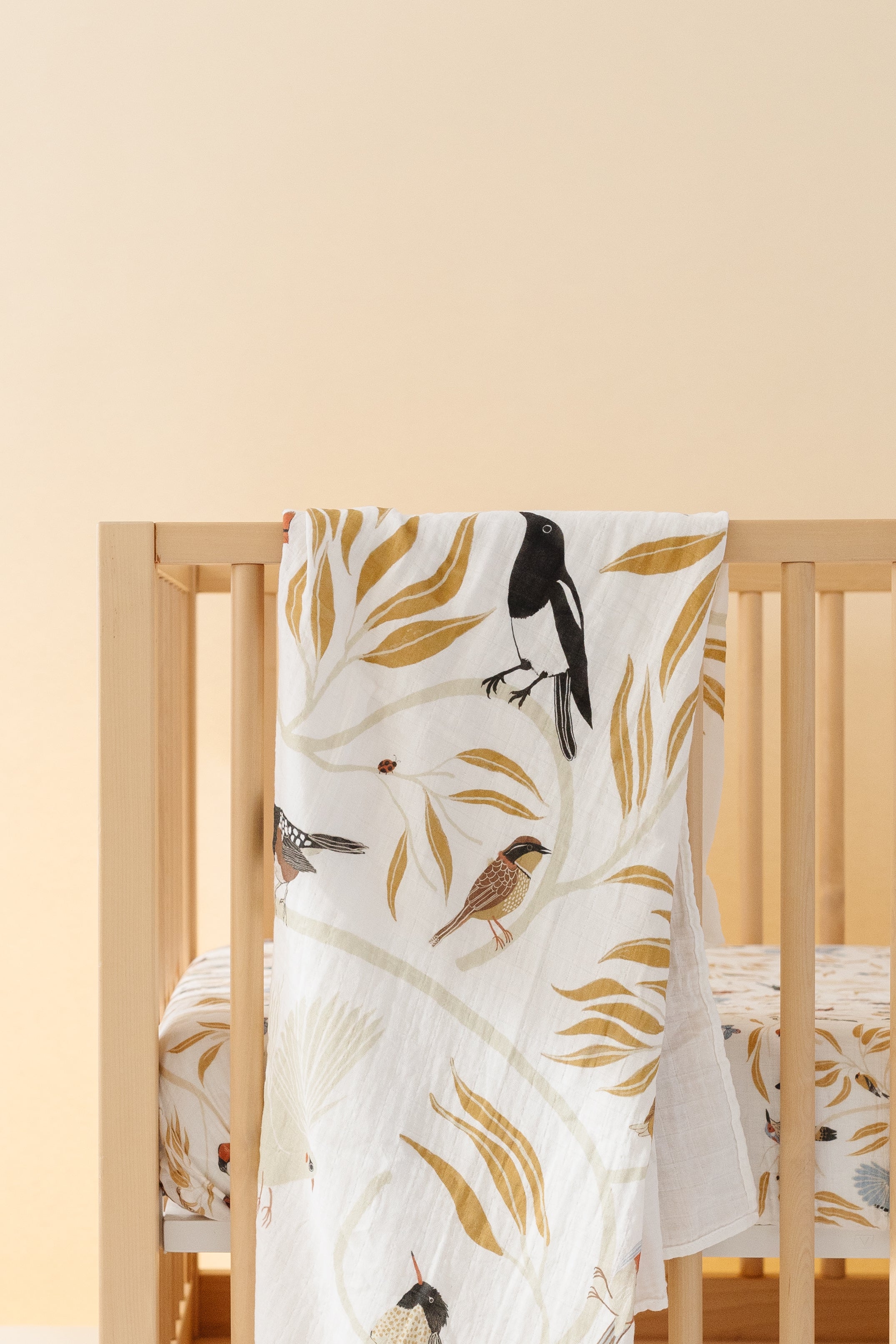 Clementine Kids bird print swaddle styled in nursery