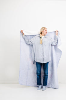 Reversible cotton muslin throw showing floral and periwinkle sides