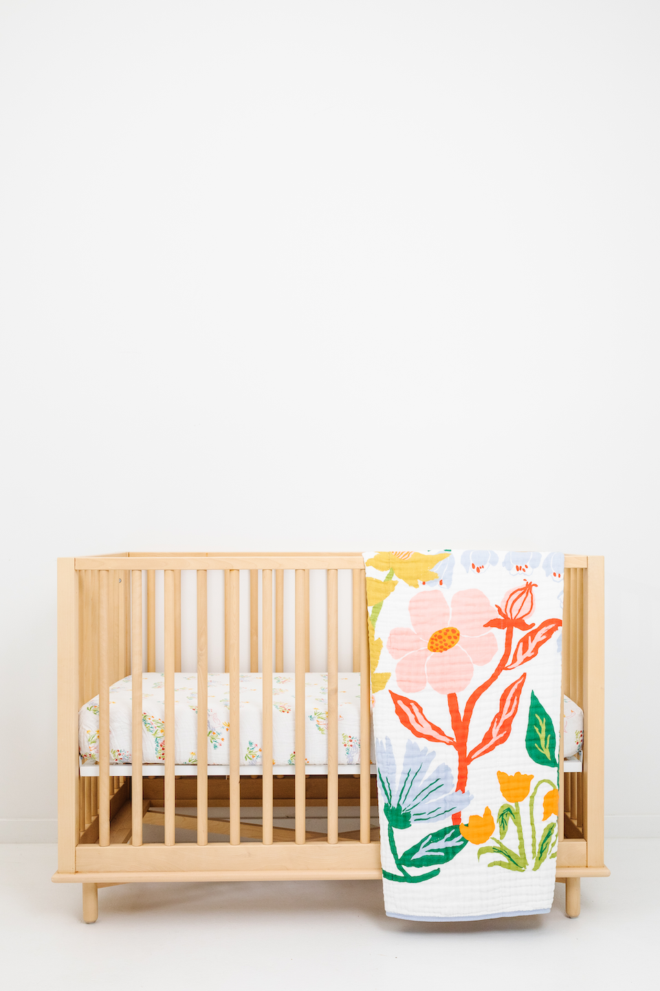 Clementine Kids Cottage Garden Quilt folded on crib