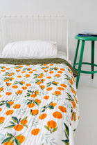 Reversible cotton muslin throw showing clementine and green sides