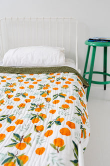 Reversible cotton muslin throw showing clementine and green sides
