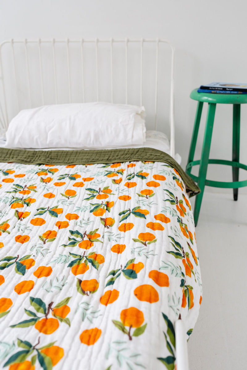 Reversible cotton muslin throw showing clementine and green sides
