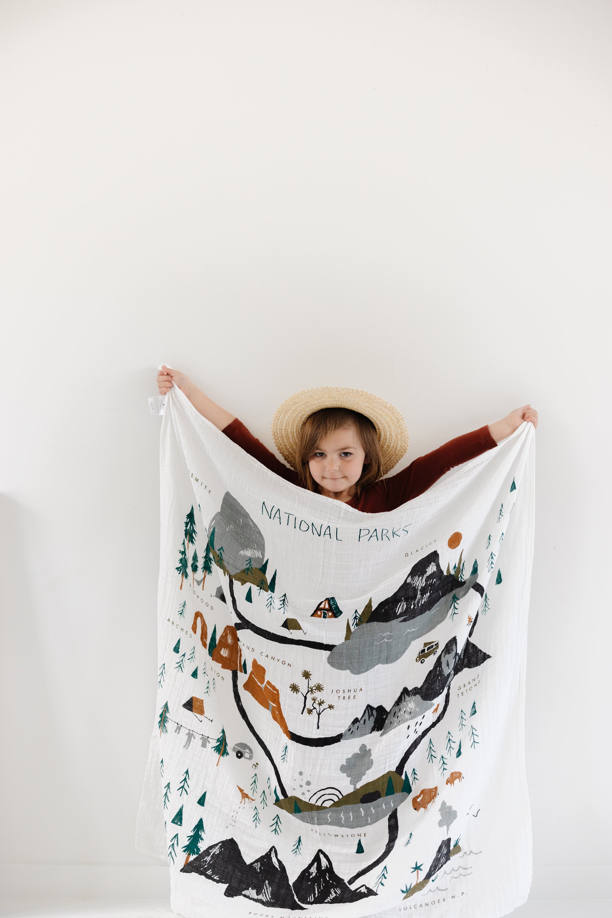 Baby wrapped in National Parks muslin swaddle blanket