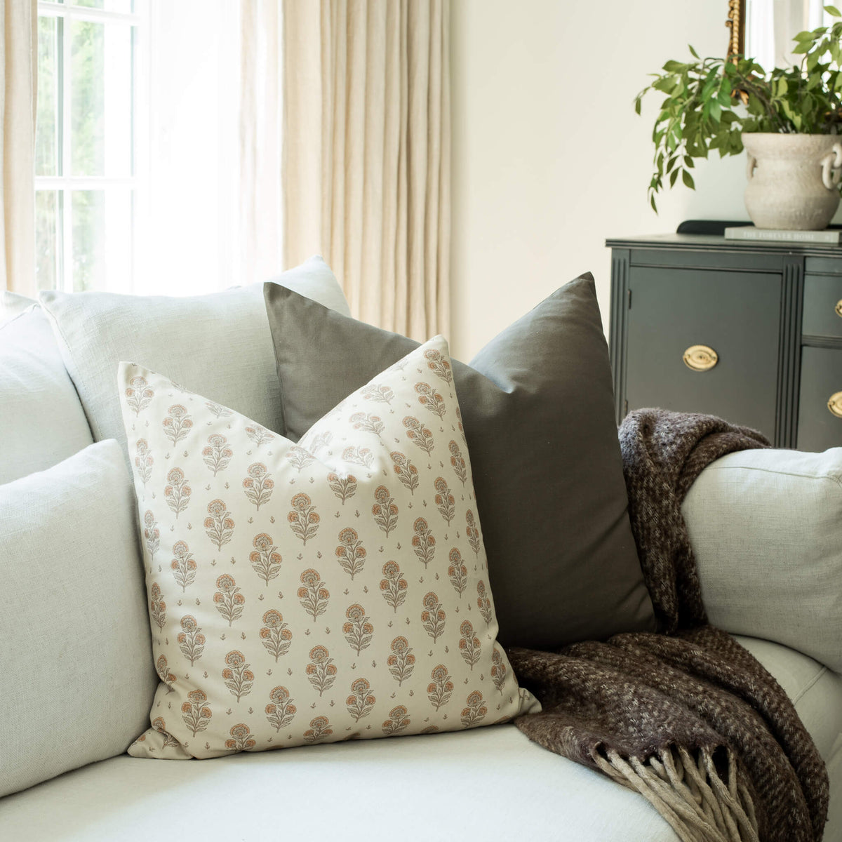 Anais blush block print throw pillow cover on a sofa