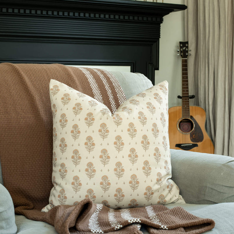 Anais cream and blush floral pillow in a cozy living room